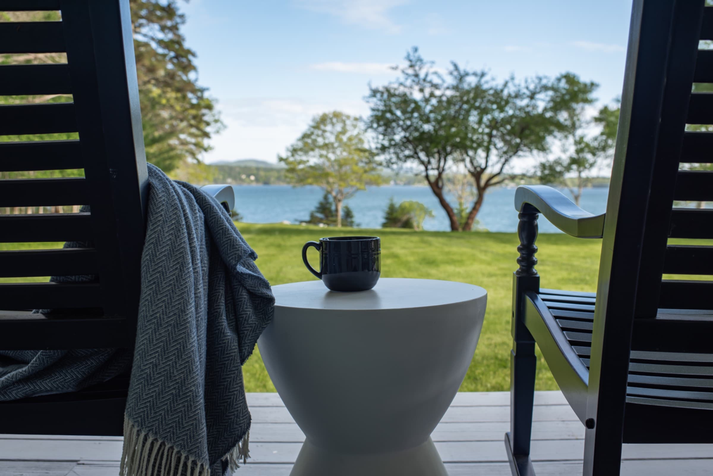 Rocking chairs, coffee, and ocean views. A serene coastal spot, where slow mornings and seaside stillness start the day.
